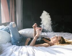 אישה מעשנת על המיטה
