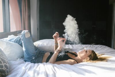 אישה מעשנת על המיטה