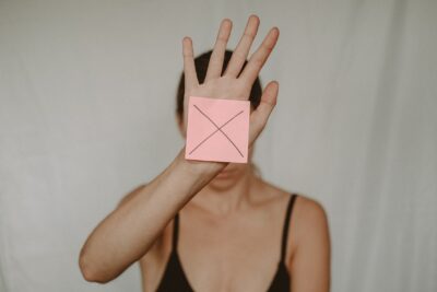אישה מחזיקה פתק עם X